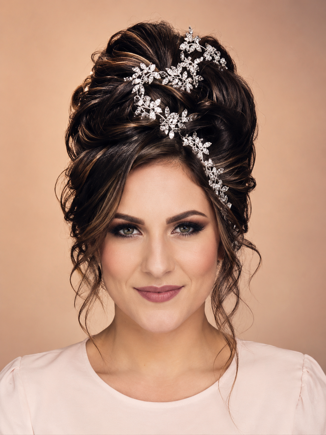 Bridal high updo with crystal floral hair vine and soft face-framing curls